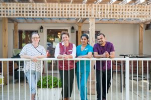 Outdoor covered patio with smiling staff members